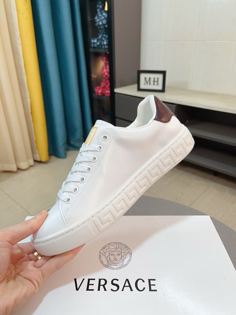 White Versace low-top sneakers with brown interior lining and embossed Greek-motif sole