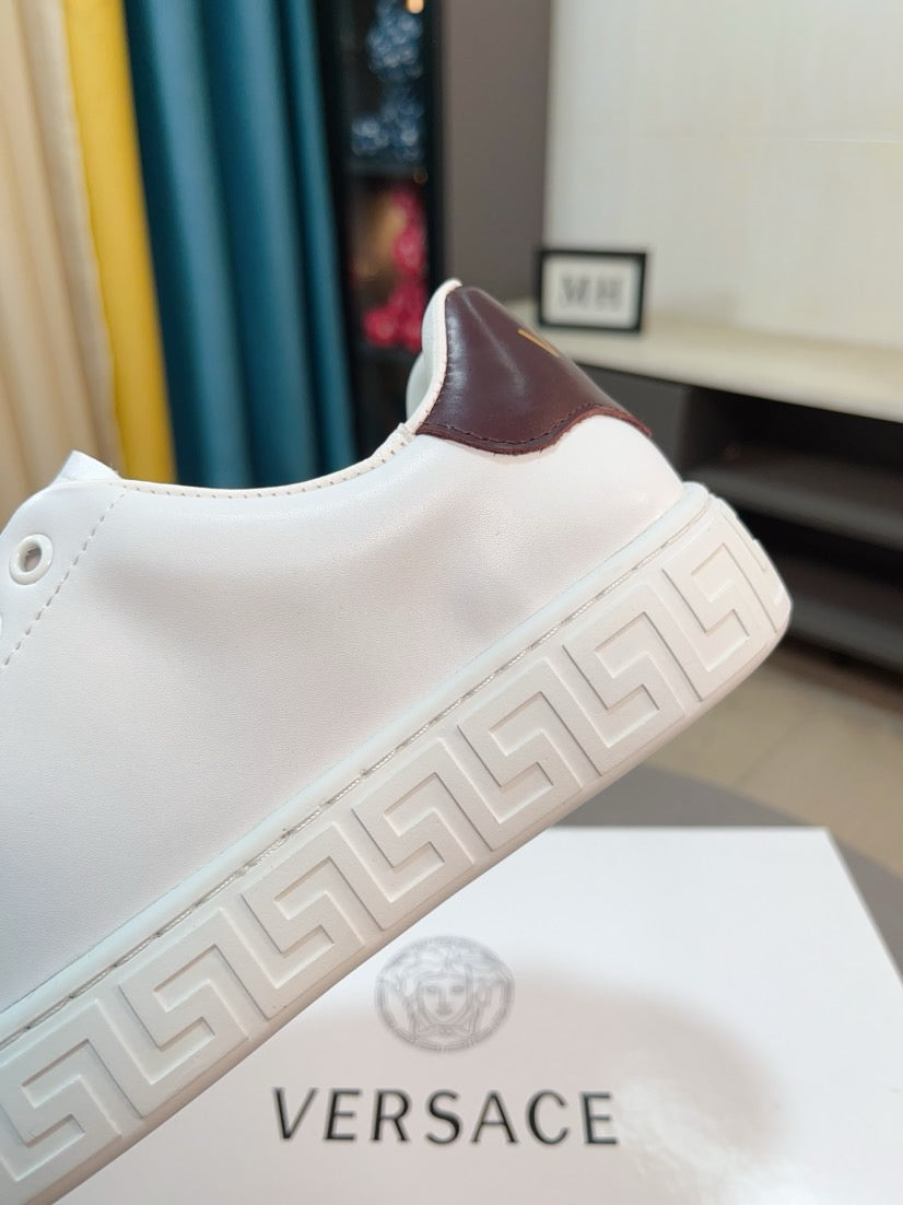White Versace low-top sneaker with brown heel lining and embossed Greek-motif side