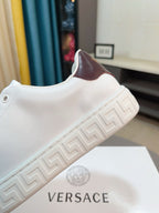 White Versace low-top sneaker with brown heel lining and embossed Greek-motif side