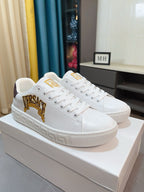 White Versace low-top sneakers with gold VERSACE crest on side and textured sole
