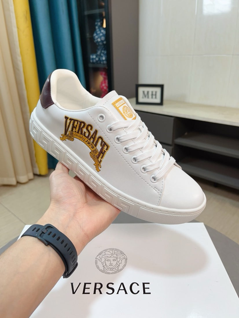 White Versace low-top sneakers with gold VERSACE crest and embossed Greek-motif sole