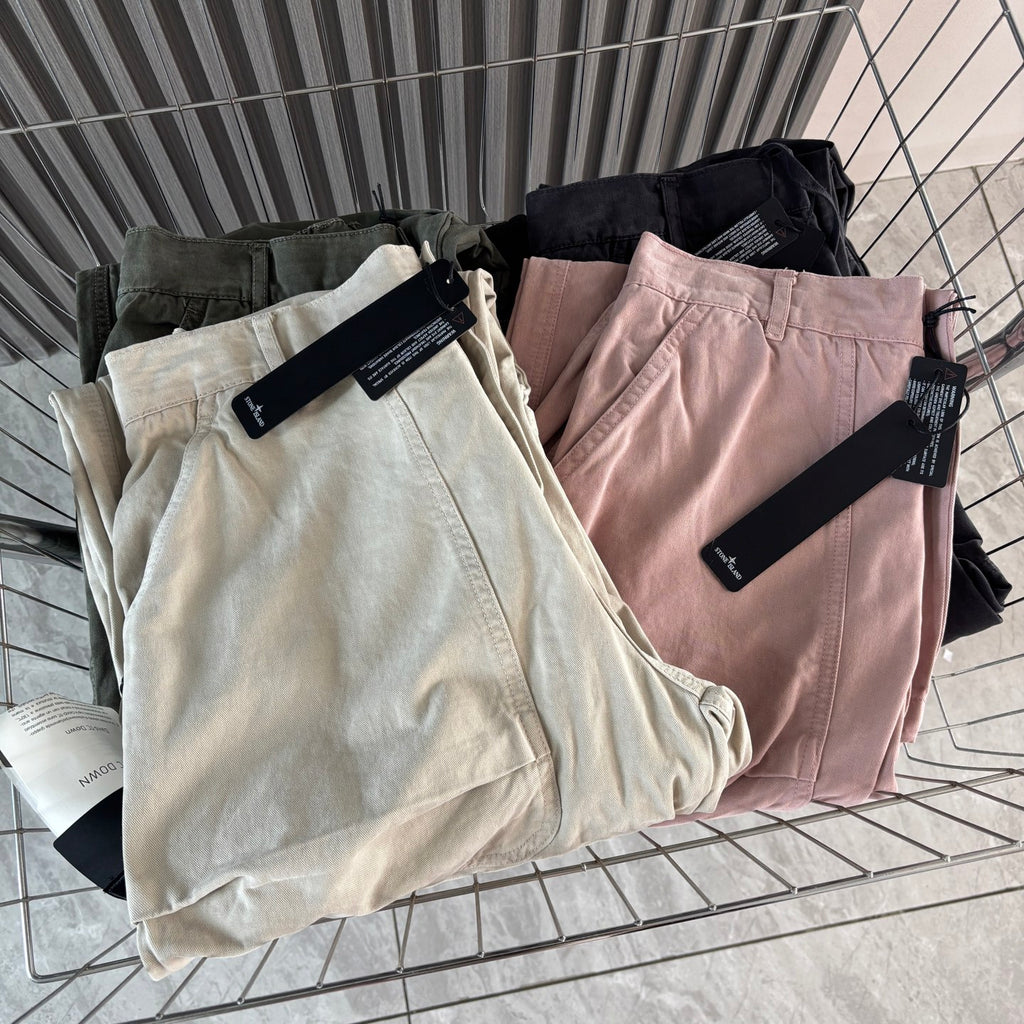 Cargo shorts folded on display in cream, pink, olive, and dark gray