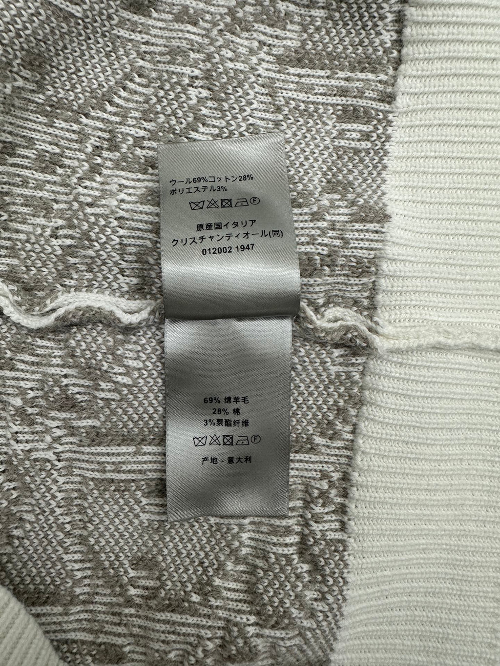 Inner care label on knit sweater fabric in gray and white with Japanese text
