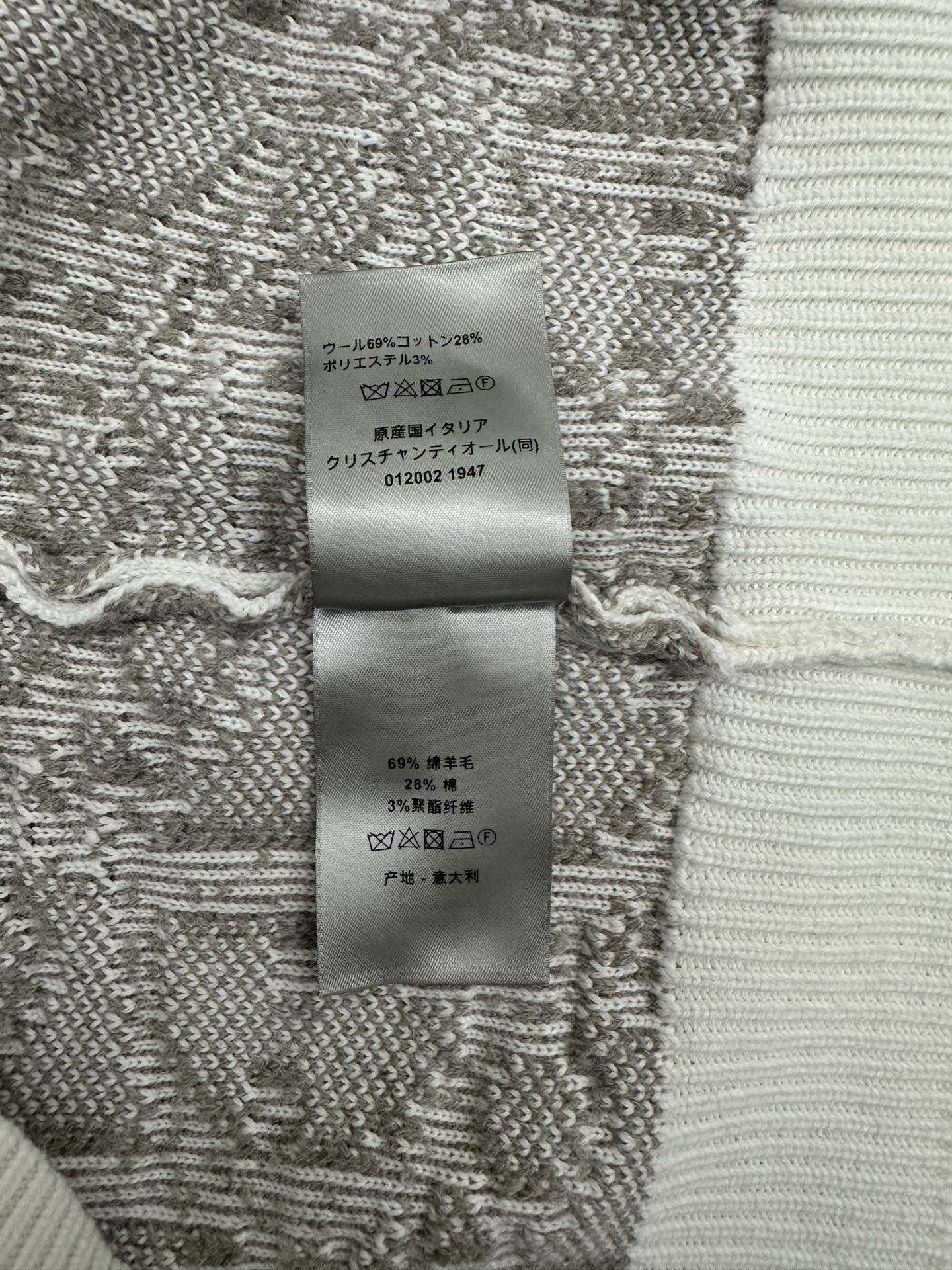 Inner care label on knit sweater fabric in gray and white with Japanese text