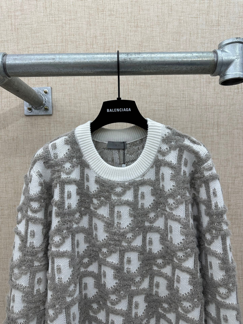 Long-sleeve knit sweater with ribbed crew neck collar and gray logo-like allover print