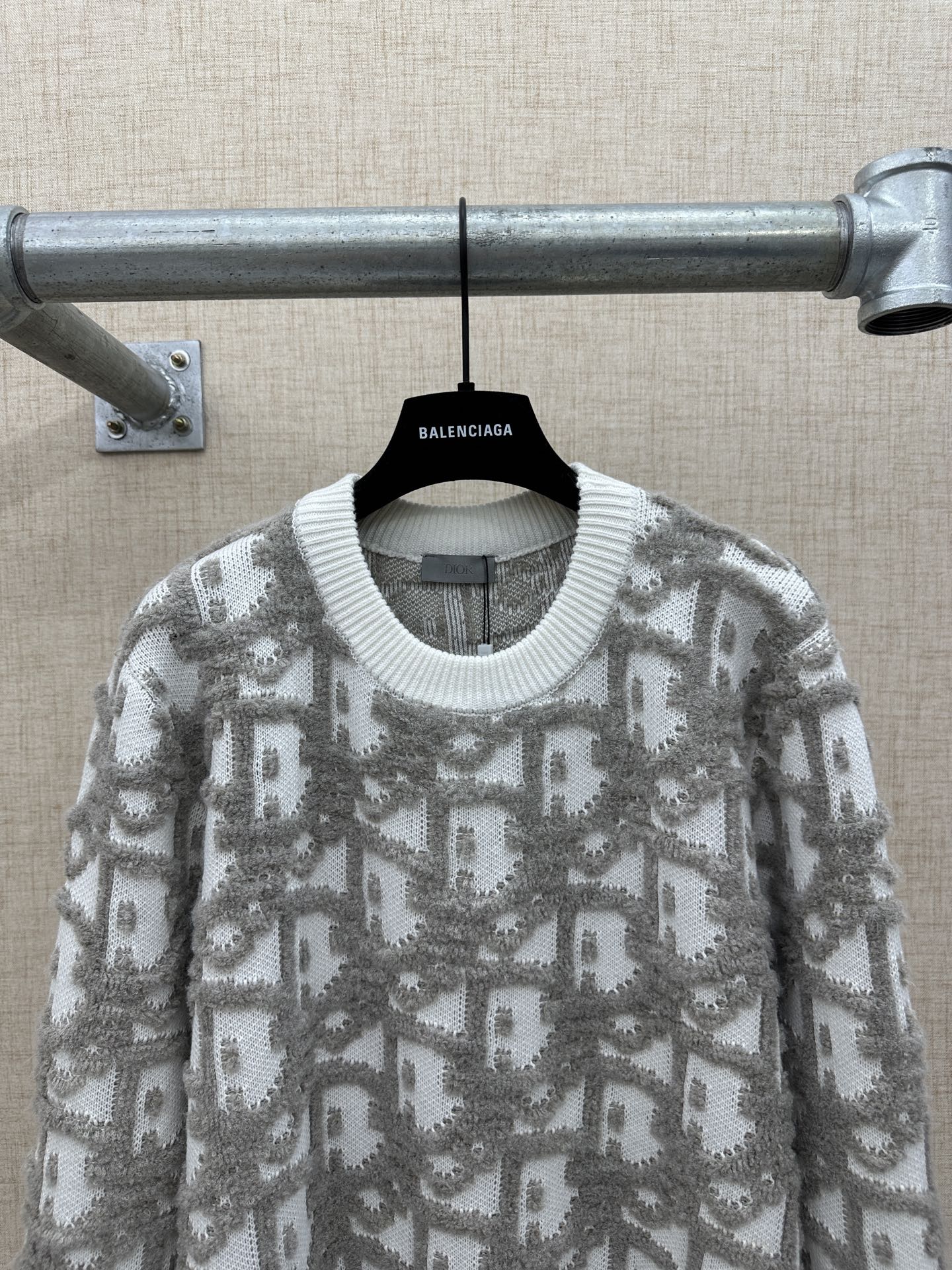Long-sleeve knit sweater with ribbed crew neck collar and gray logo-like allover print
