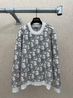 Long-sleeve knit sweater in light gray with allover logo-like print and ribbed hem
