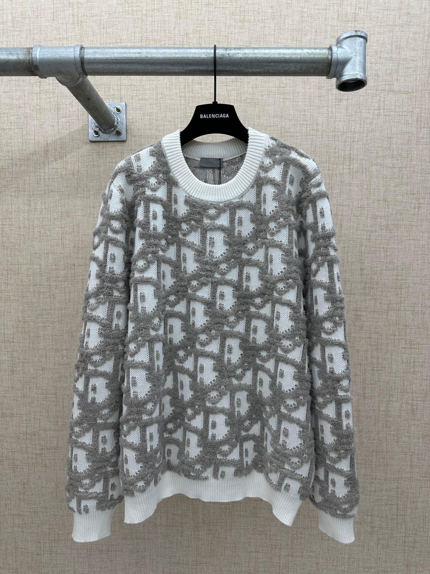 Long-sleeve knit sweater in light gray with allover logo-like print and ribbed hem