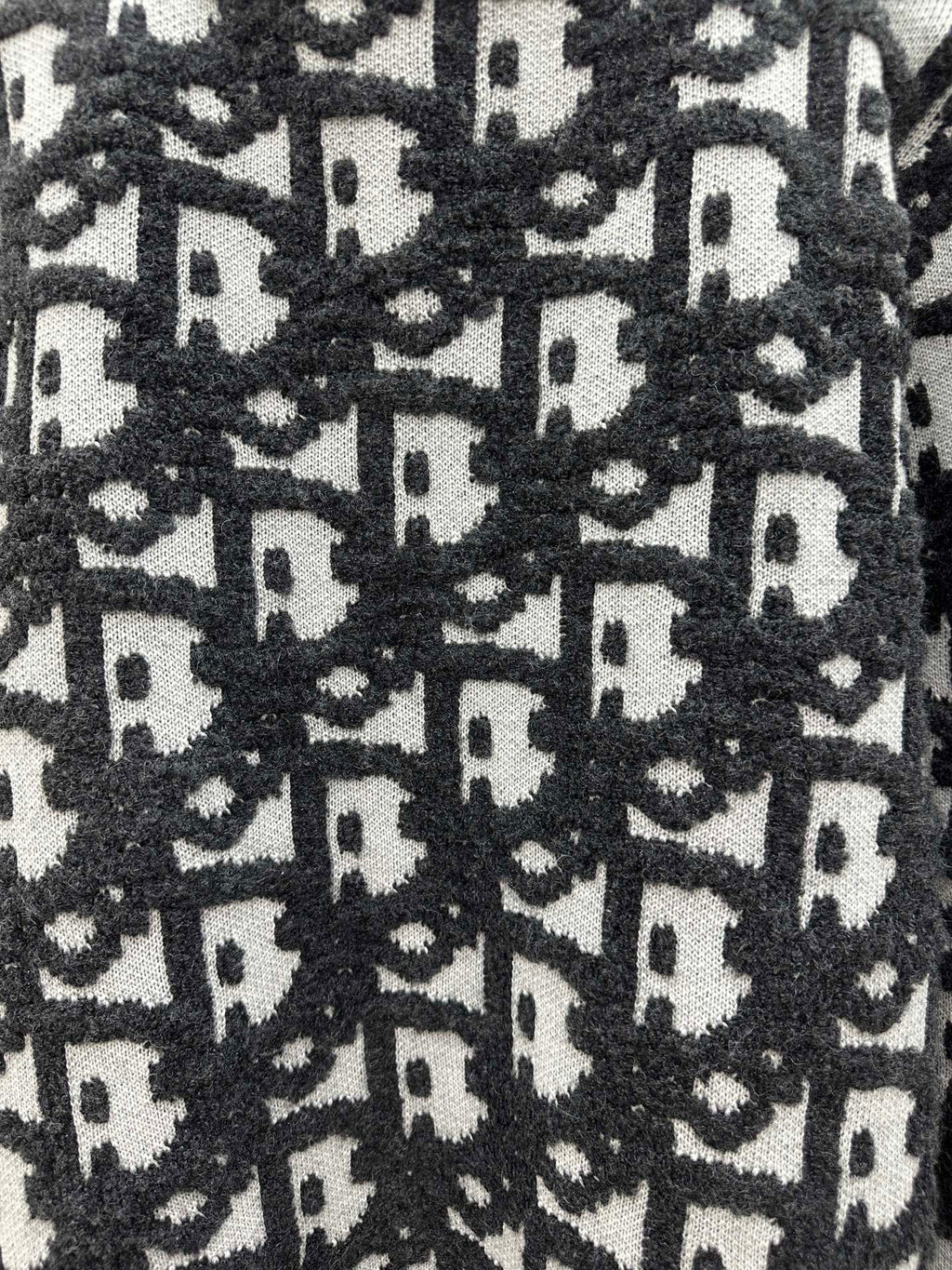 Close-up of black and white monogram knit texture on sweater