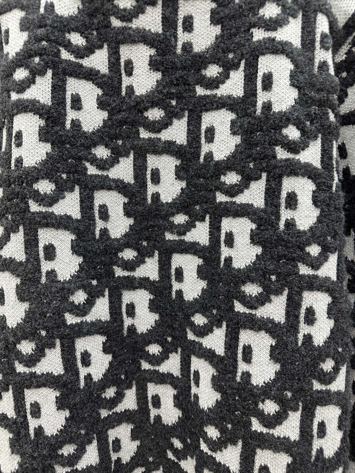 Close-up of black and white monogram knit texture on sweater