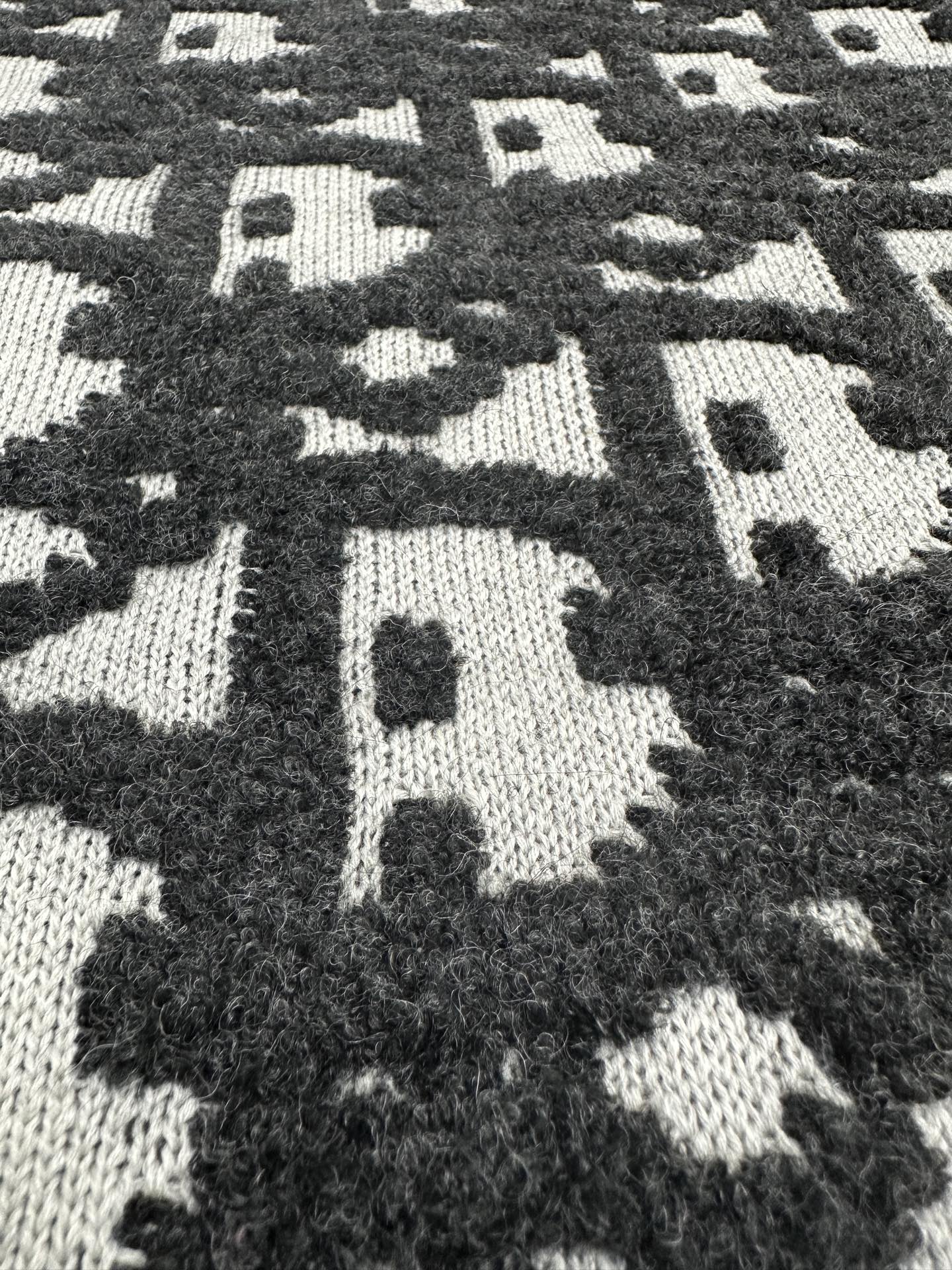 Black and white monogram jacquard knit fabric panel, high-contrast pattern