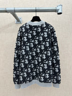 Black and white patterned knit sweater with ribbed crew neck and long sleeves