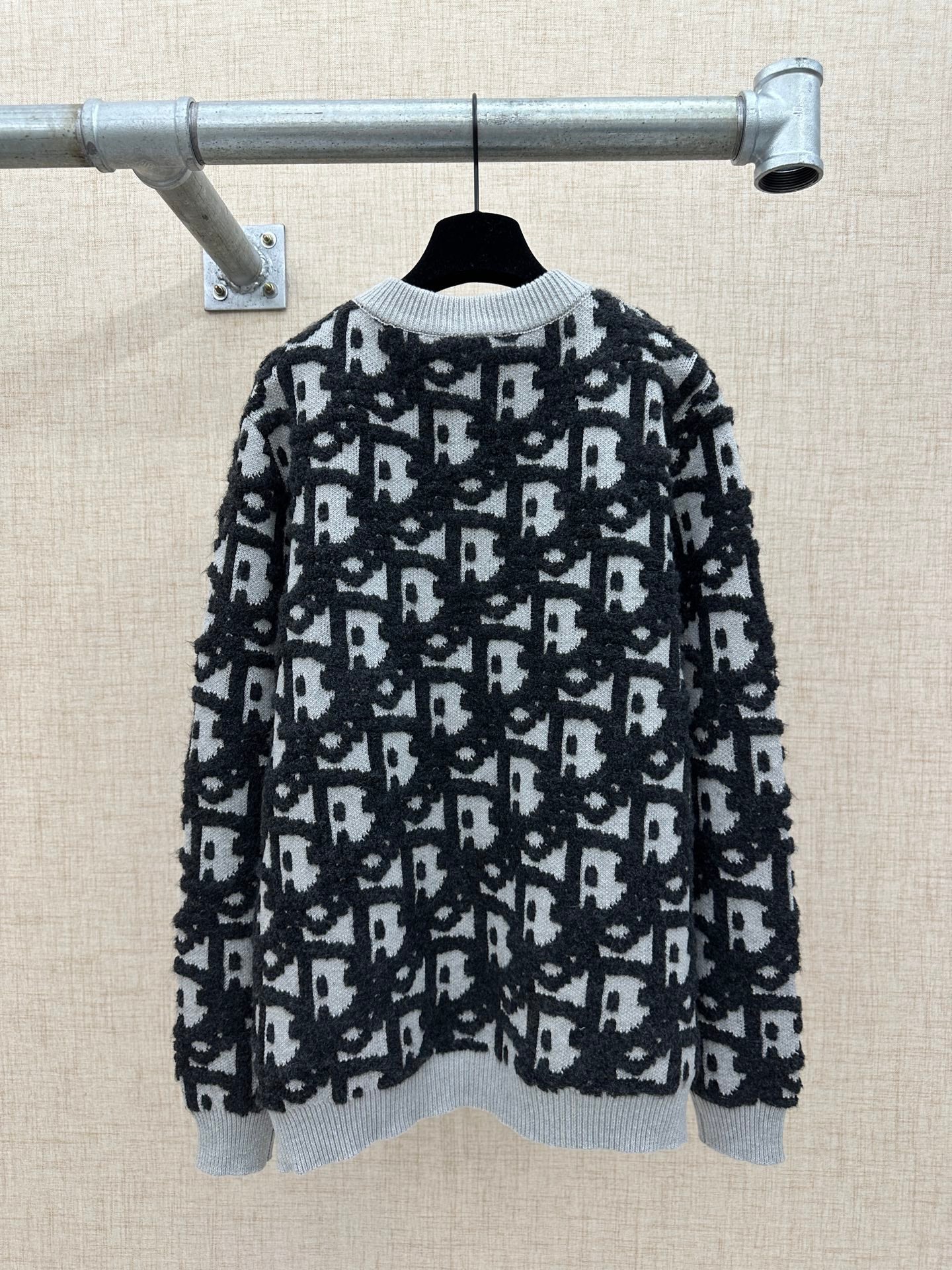 Black and white patterned knit sweater with ribbed crew neck and long sleeves