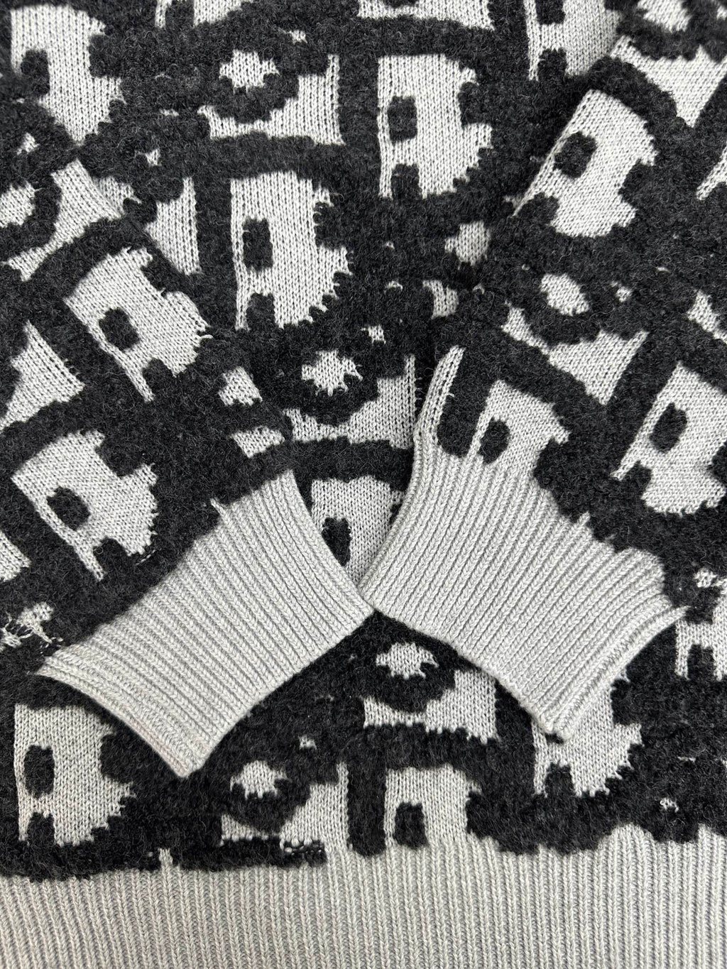 Close-up of black and white monogram knit sweater with ribbed collar