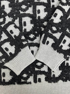 Close-up of black and white monogram knit sweater with ribbed collar