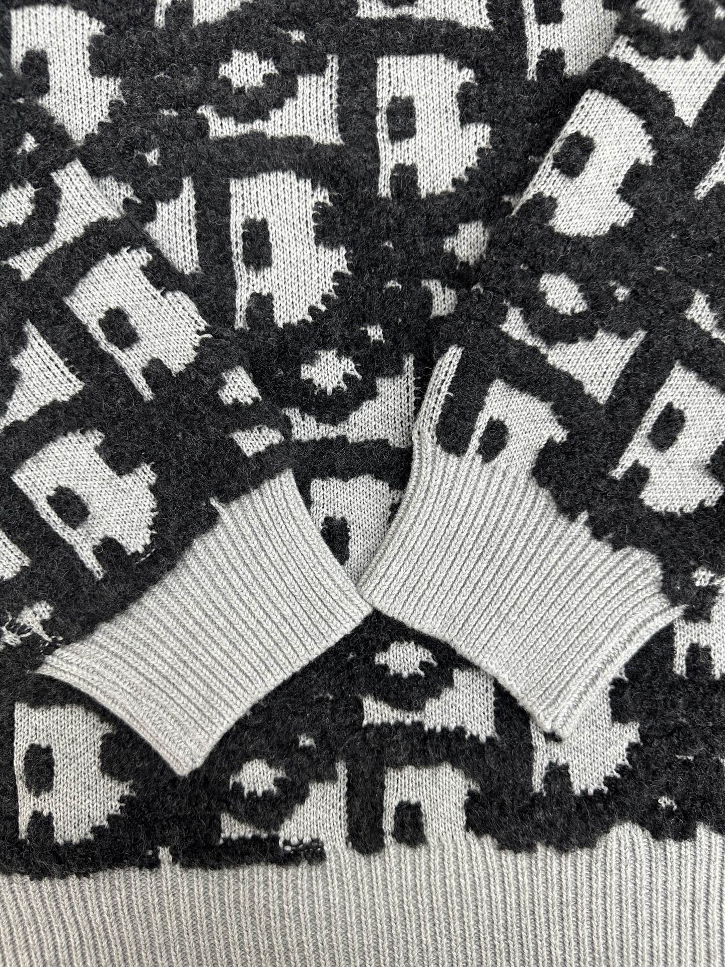 Close-up of black and white monogram knit sweater with ribbed collar