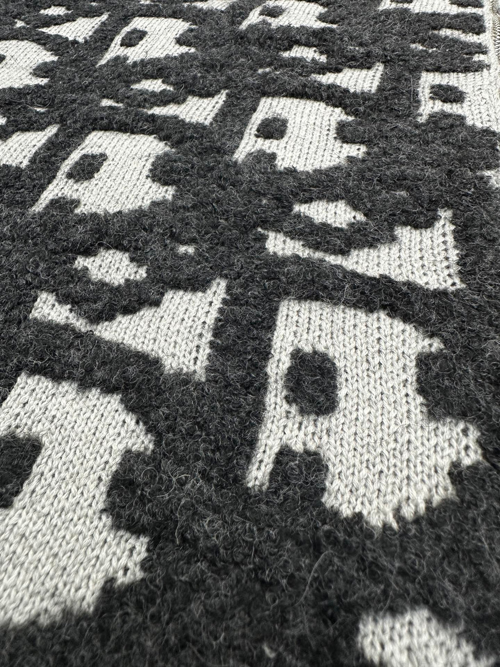 Dior jacquard knit fabric close-up, dark and white scattered logo pattern