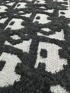 Dior jacquard knit fabric close-up, dark and white scattered logo pattern