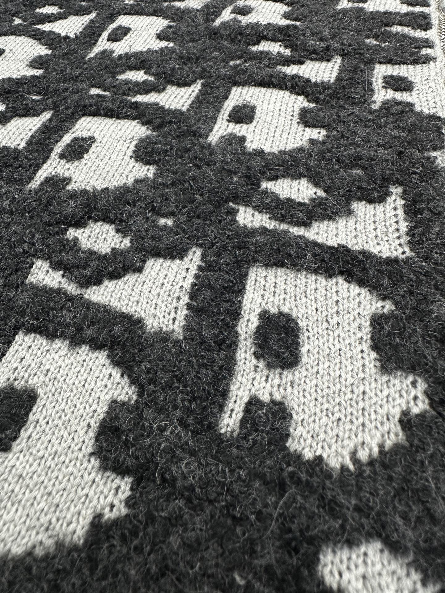 Dior jacquard knit fabric close-up, dark and white scattered logo pattern