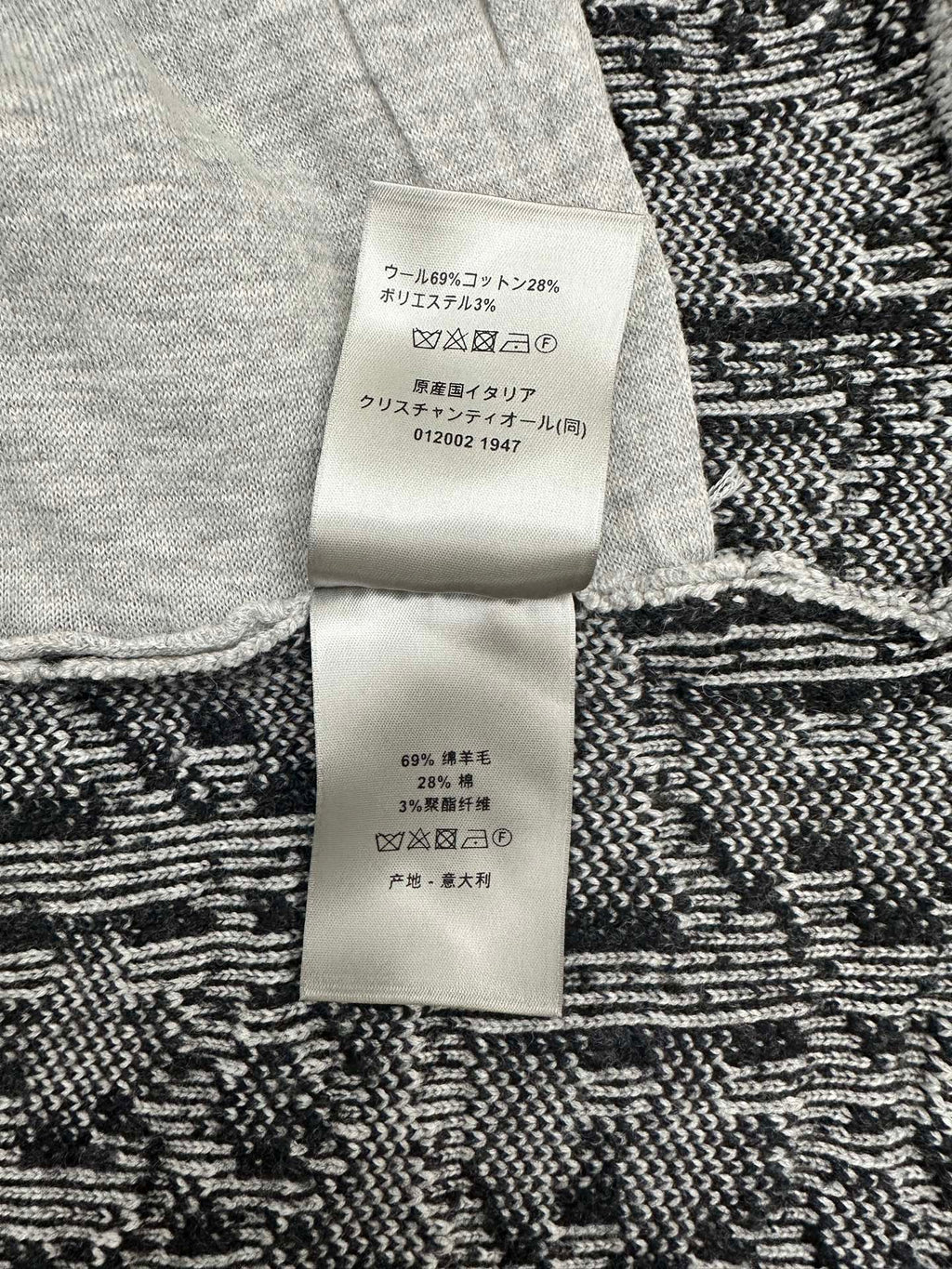 Clothing care label on knit cardigan, with fabric composition text