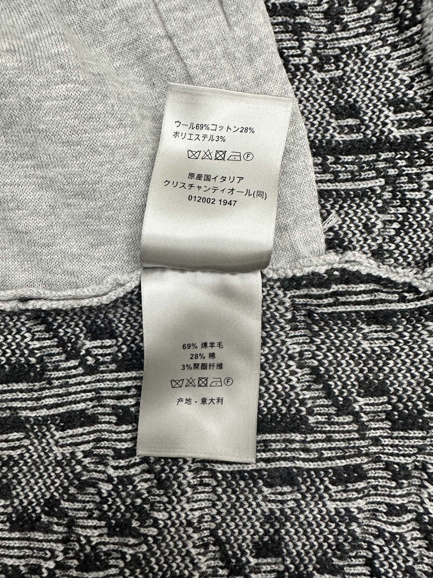 Clothing care label on knit cardigan, with fabric composition text