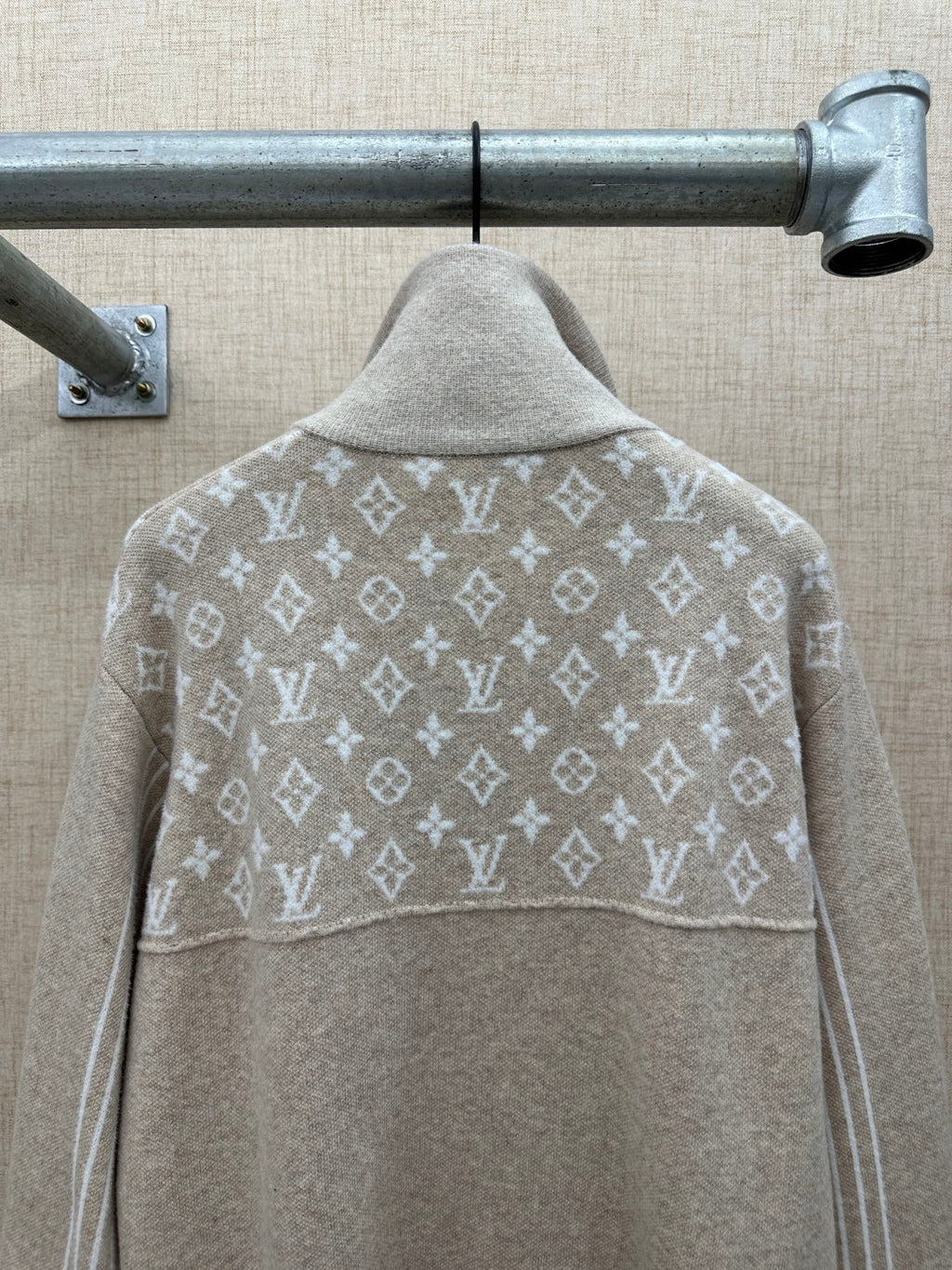 Beige hoodie back with white monogram pattern across shoulders