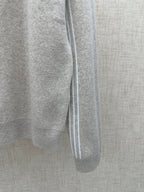 Long-sleeve top in light gray knit with white-trimmed side seam and ribbed cuff