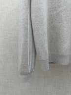 Beige long-sleeve hoodie sleeve with white vertical stripe trim at cuff