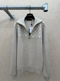 Beige long-sleeve hoodie with white monogram pattern and front zip