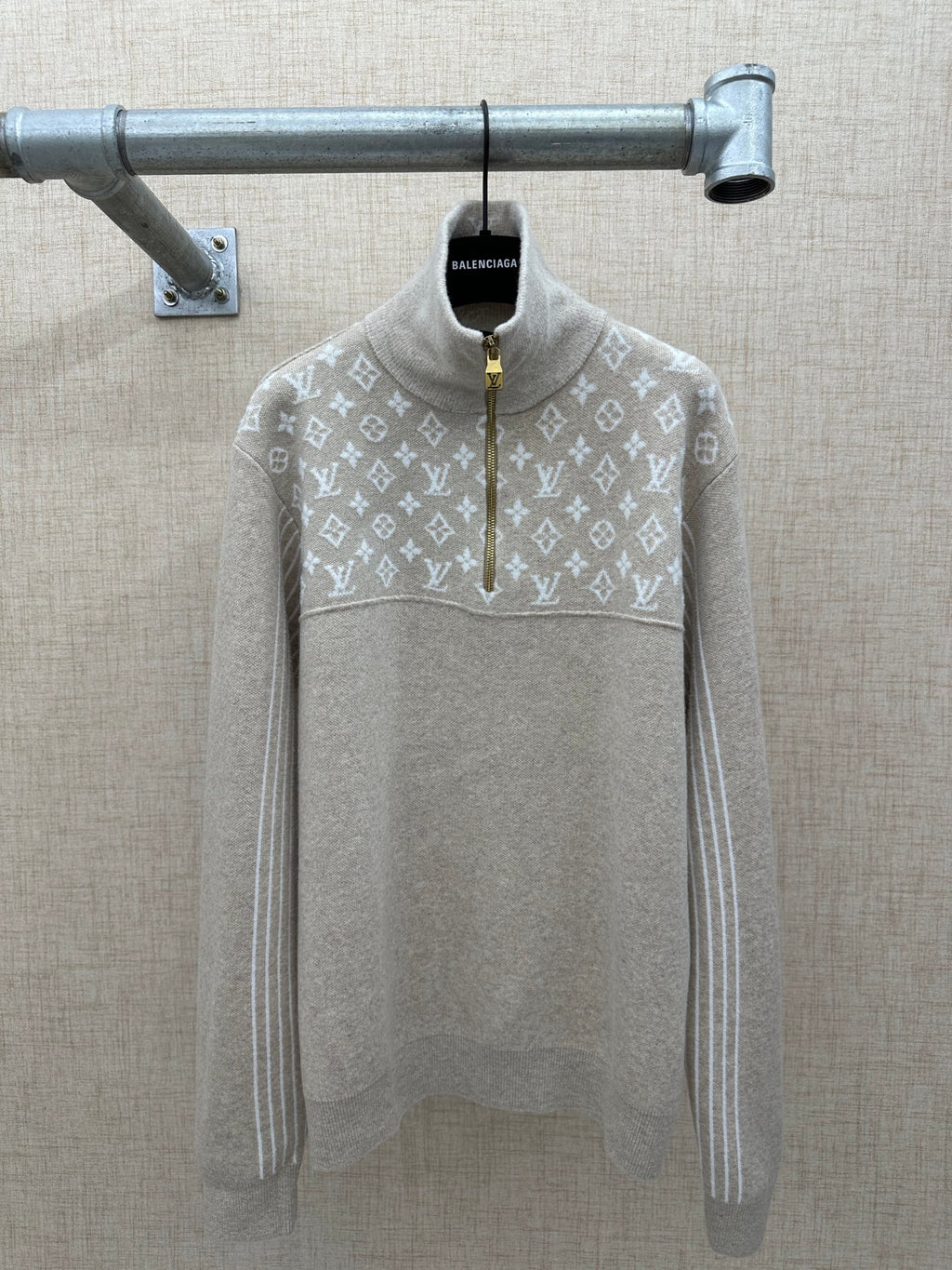 Beige long-sleeve hoodie back with white monogram pattern and front half-zip