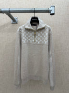 Beige long-sleeve hoodie with white monogram pattern, half-zip and hood