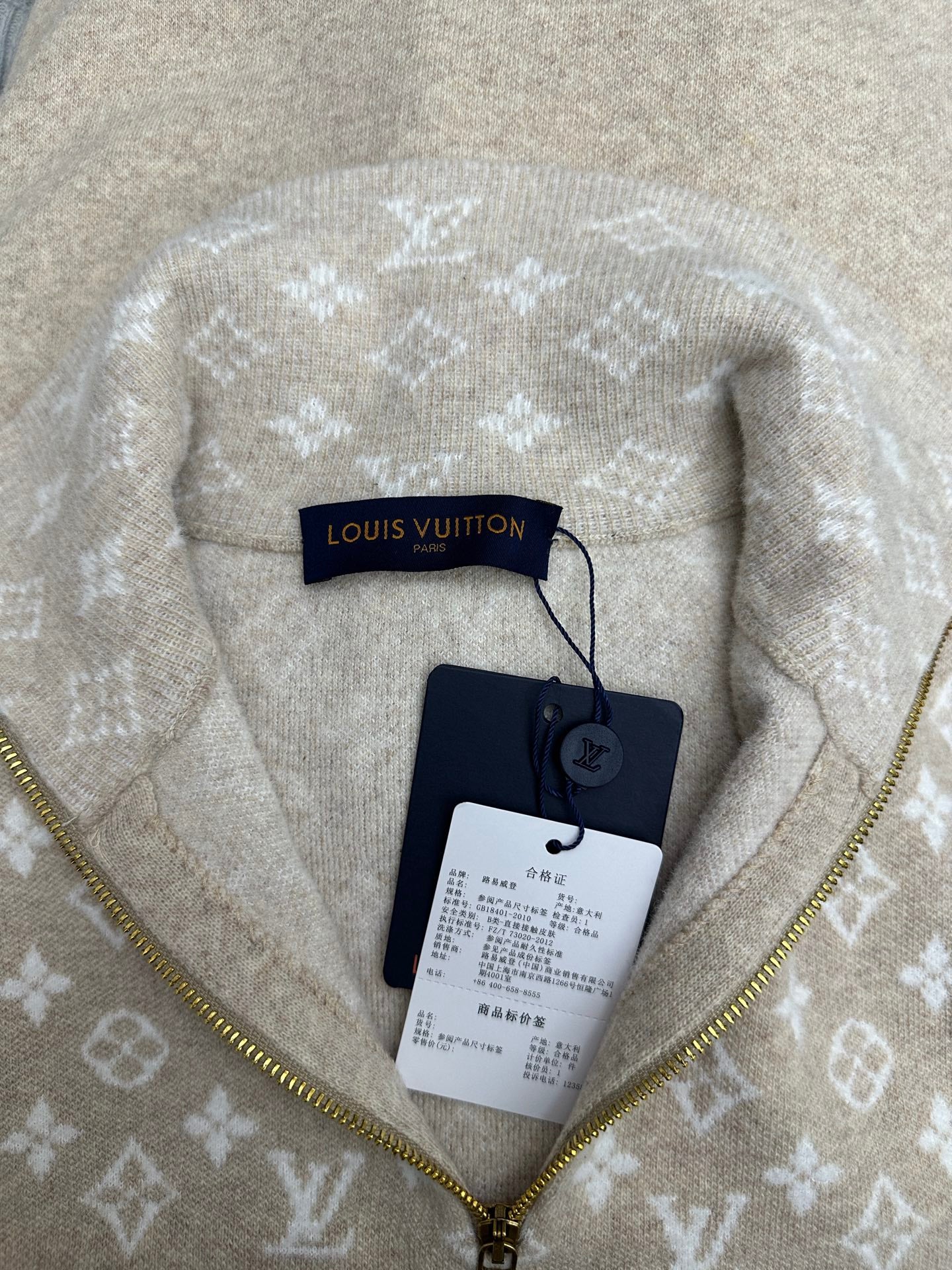 Beige hoodie with white monogram fabric and gold zipper, with hang tag