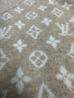 Long-sleeve top close-up with light gray knit and white monogram-style pattern