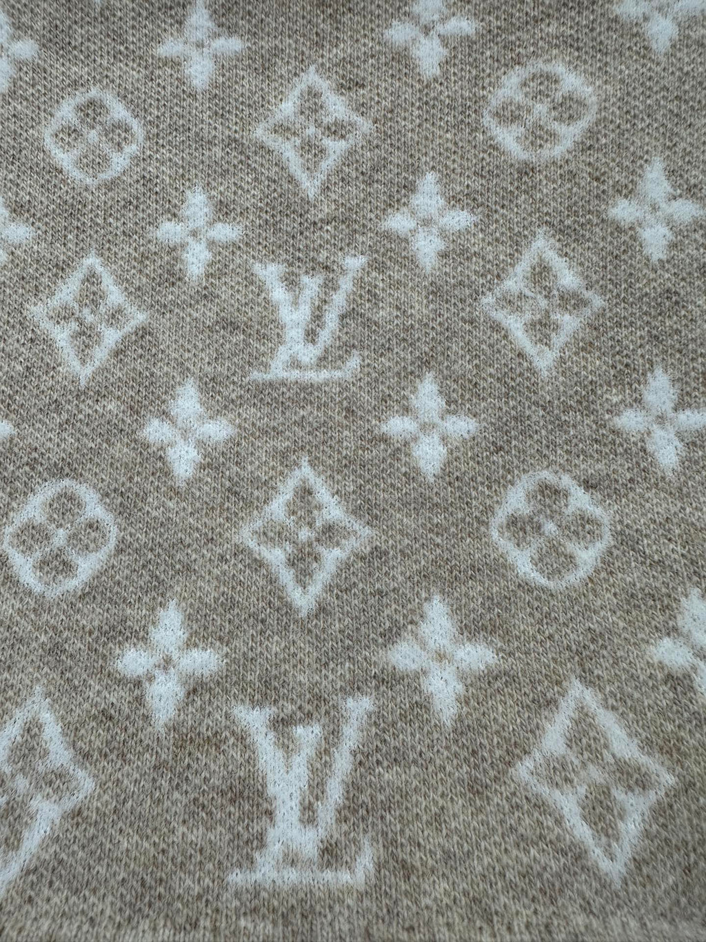 Beige knit fabric with scattered white monogram motifs