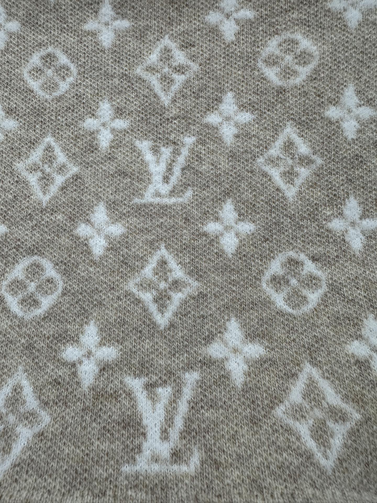 Beige knit fabric with scattered white monogram motifs