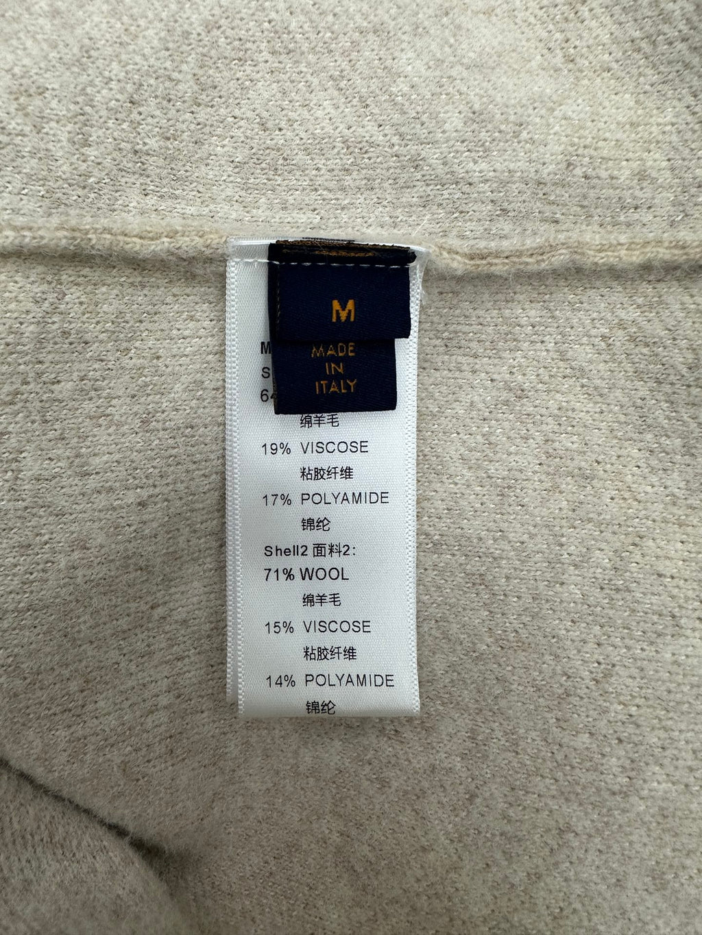 Beige fabric care label with material percentages, including viscose and wool