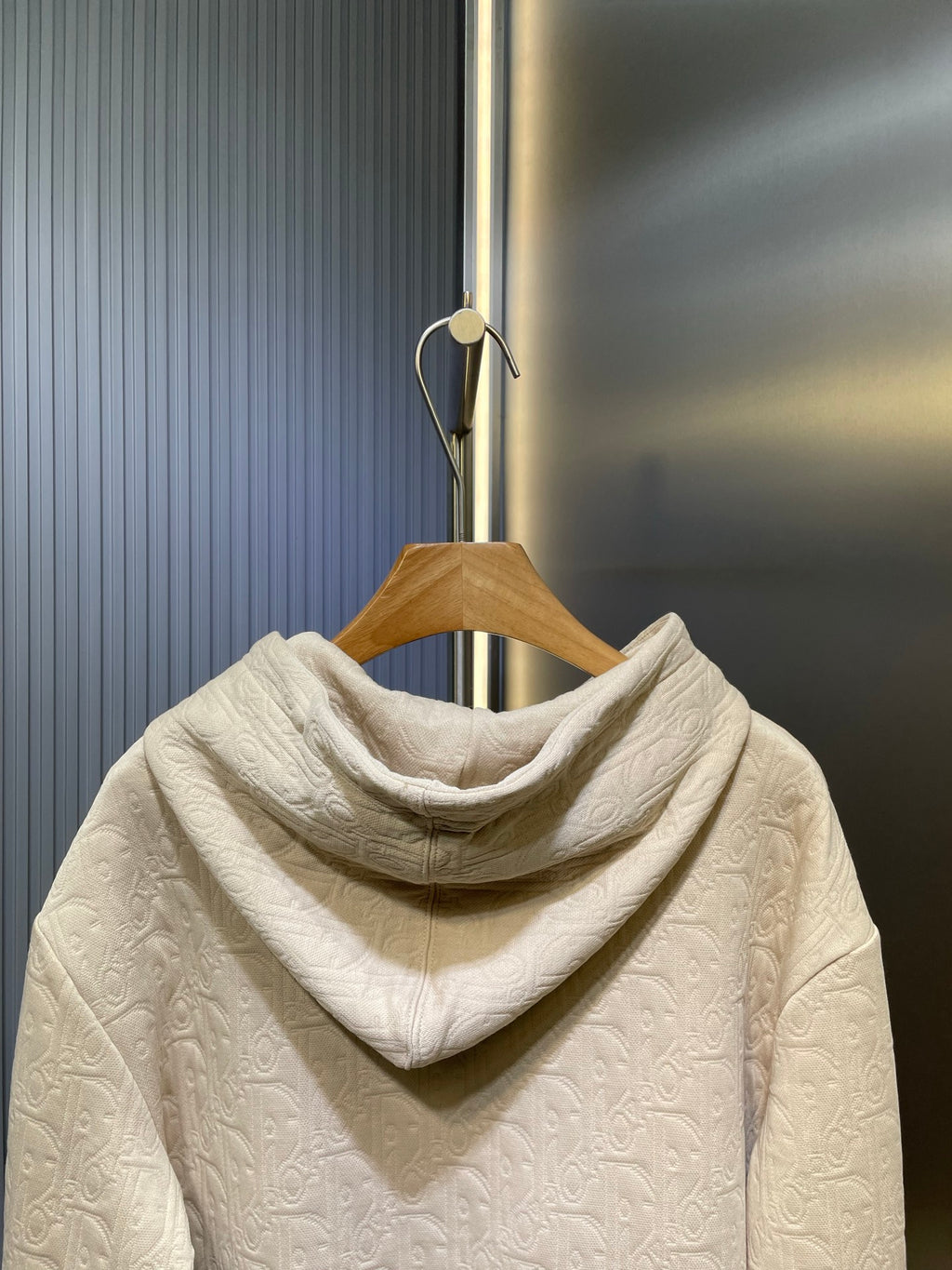 Cream embossed hoodie with attached hood, shown from the back