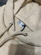 Cream embossed hoodie fabric with drawstring cords and metal aglets