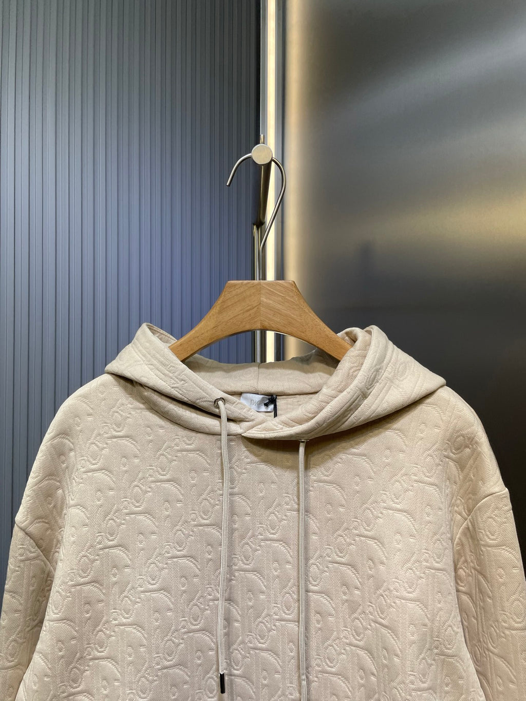 Cream embossed hoodie with drawstring hood and textured knit surface