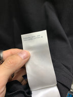 Black shorts with white care label showing 100% cotton