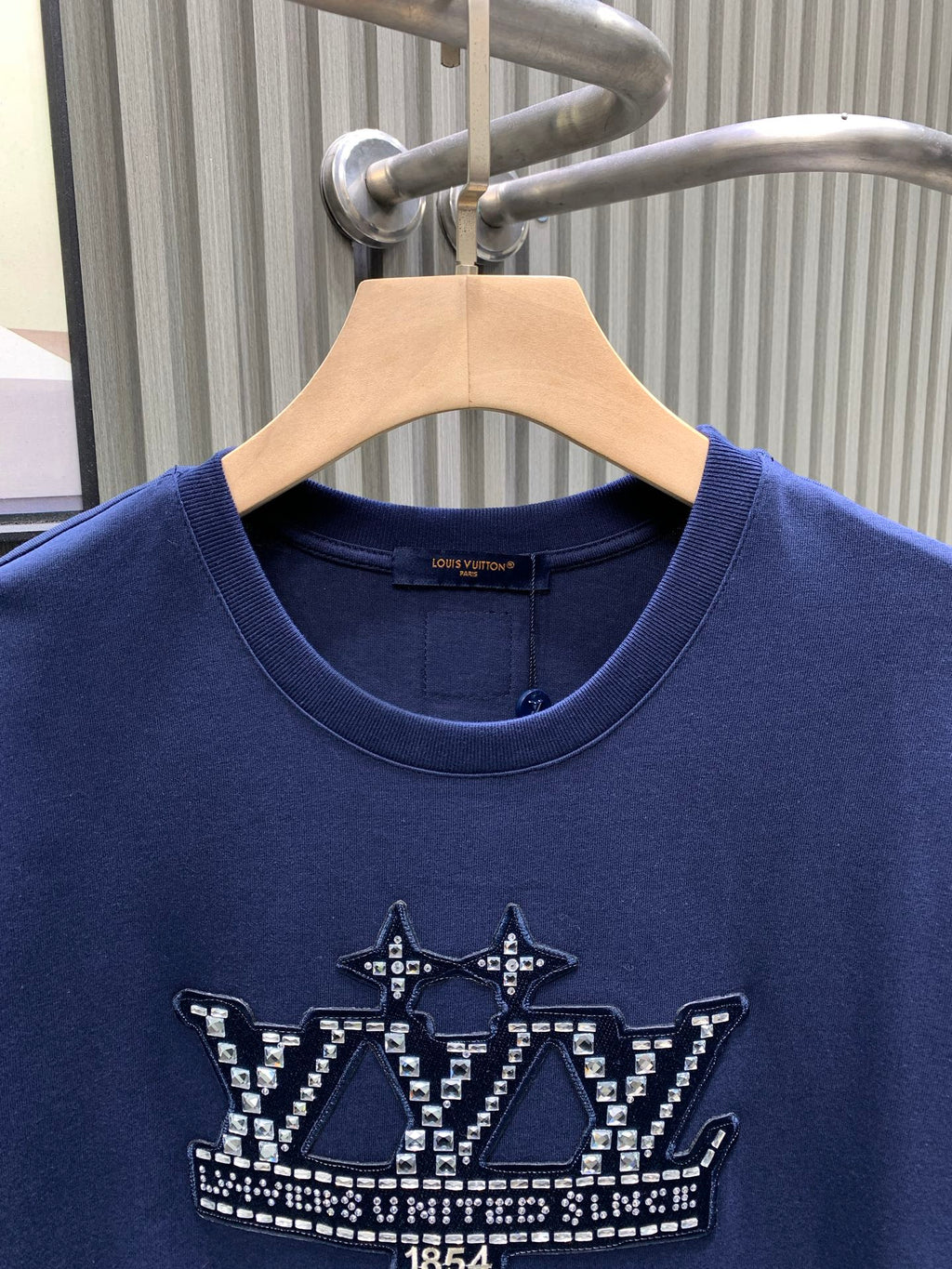 Blue T-shirt close-up of crew neck and front crown graphic detail.