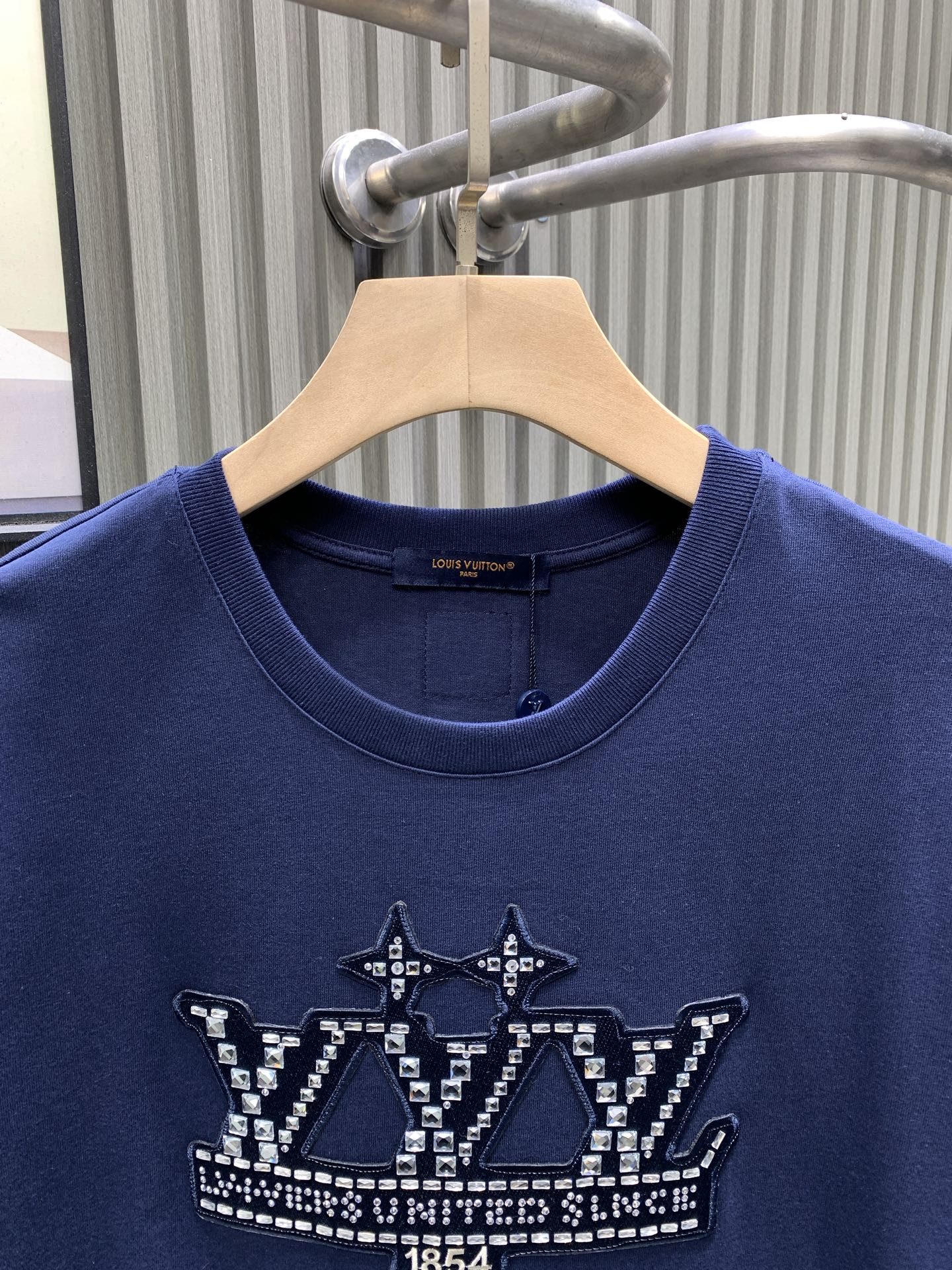 Blue T-shirt close-up of crew neck and front crown graphic detail.