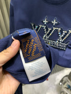 Blue T-shirt fabric care label and neckline tag held by hand.