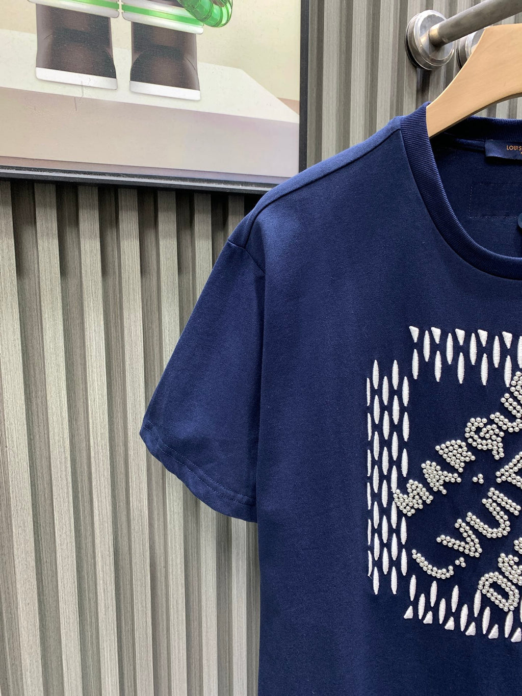Navy short-sleeve T-shirt with rhinestone logo graphic, side view