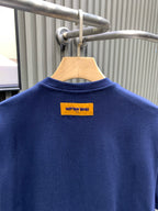 Navy short-sleeve T-shirt with yellow brand label at upper back