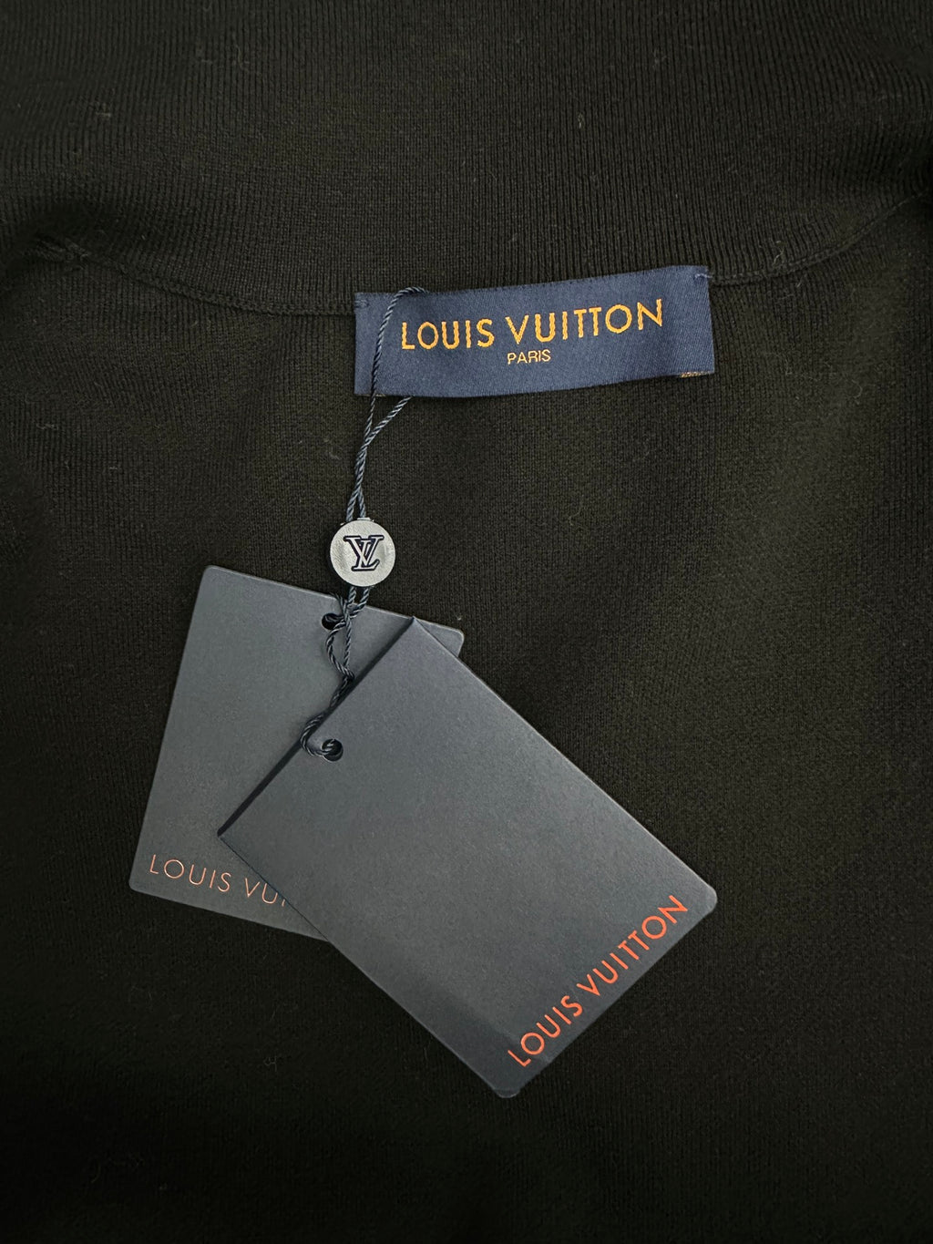 Louis Vuitton clothing tag attached to black garment