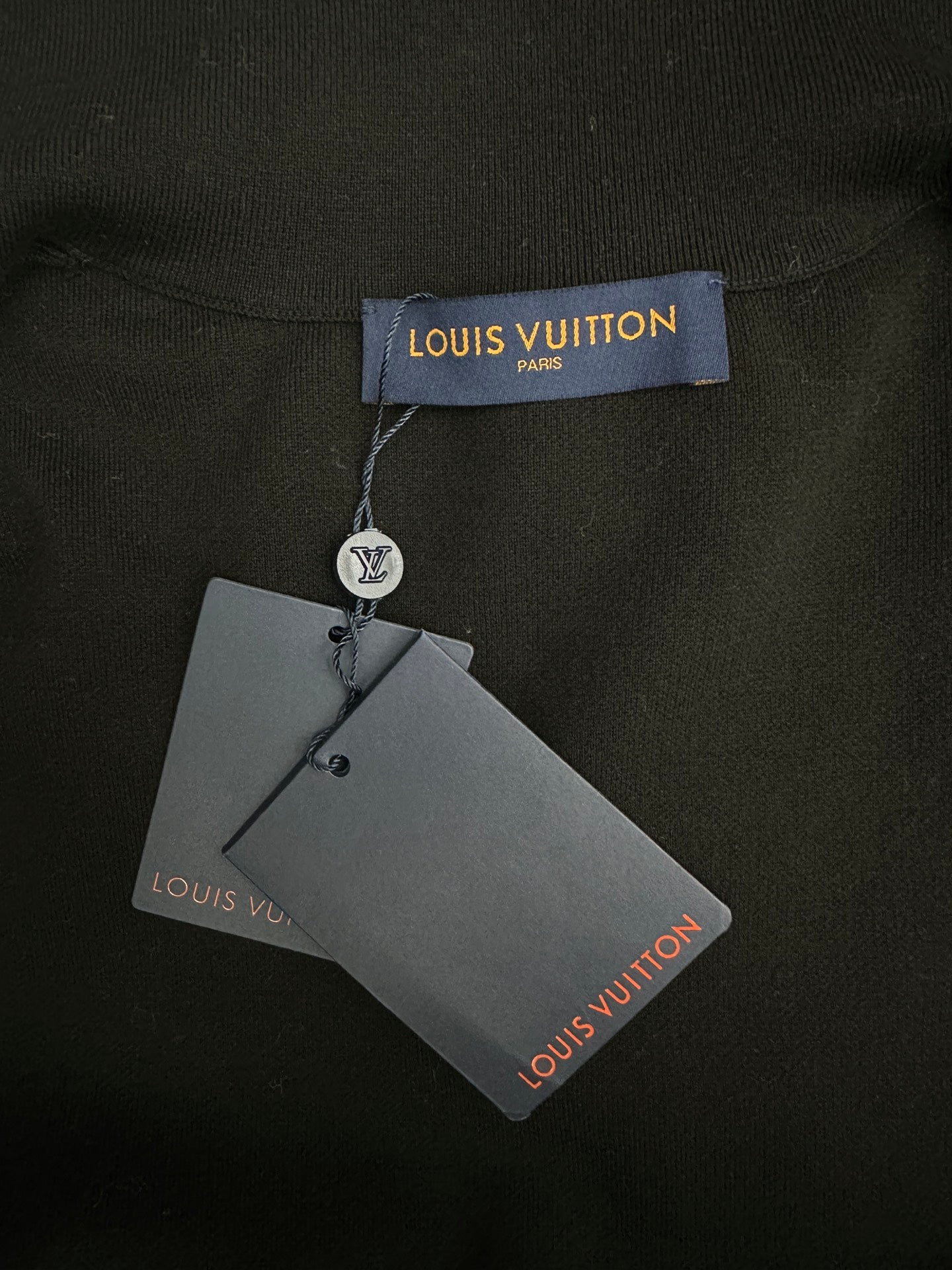 Louis Vuitton clothing tag attached to black garment