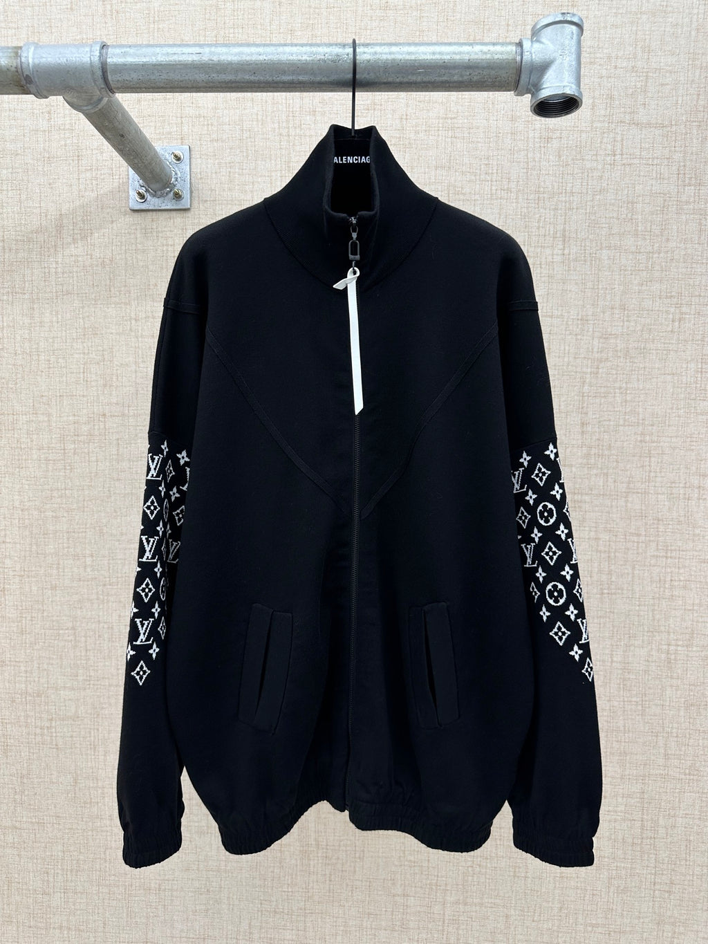 Black zip-front jacket with high collar and logo-print sleeve panels