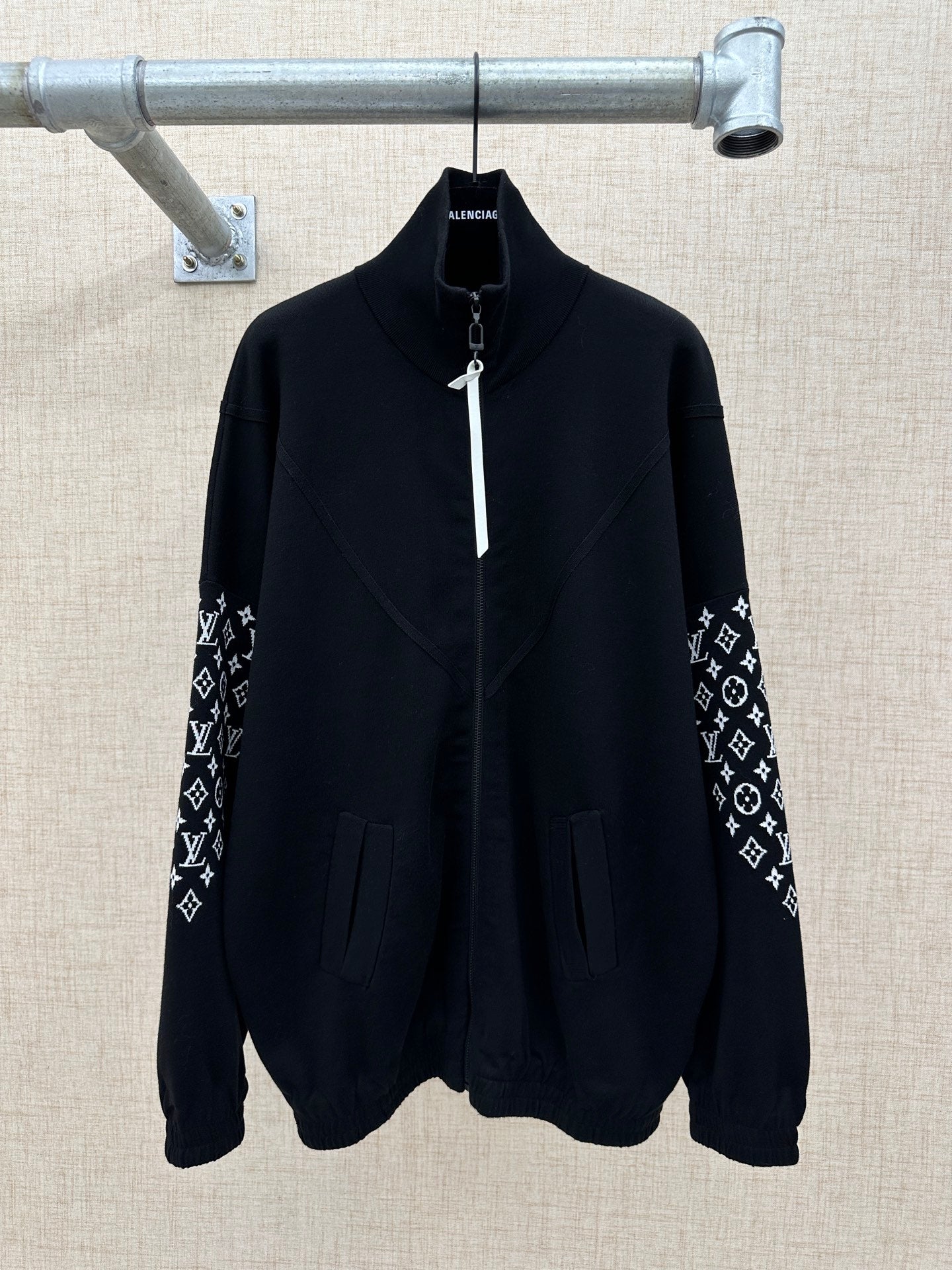 Black zip-front jacket with high collar and logo-print sleeve panels