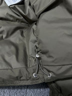 Puffer jacket hem with drawstring and small logo patch on olive lining